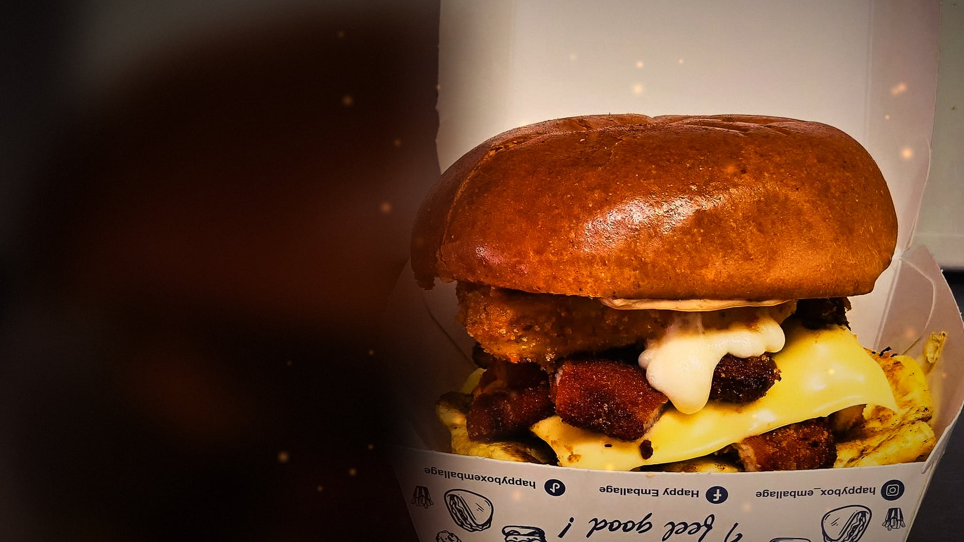 Un burger au pain brioché, poulet pané croustillant et fromage fondu, dans sa boîte Whoopy